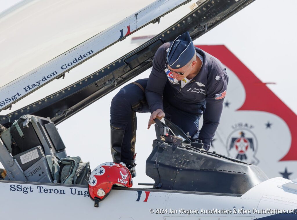 A U.S. Air Force pilot climbs into the cockpit of a fighter jet, with a red helmet resting on the aircraft’s edge. The names "SSgt Haydon Codden" and "SSgt Teron Ung" are visible.