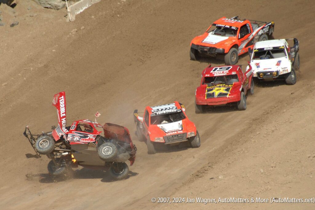 A group of trucks on a dirt track.