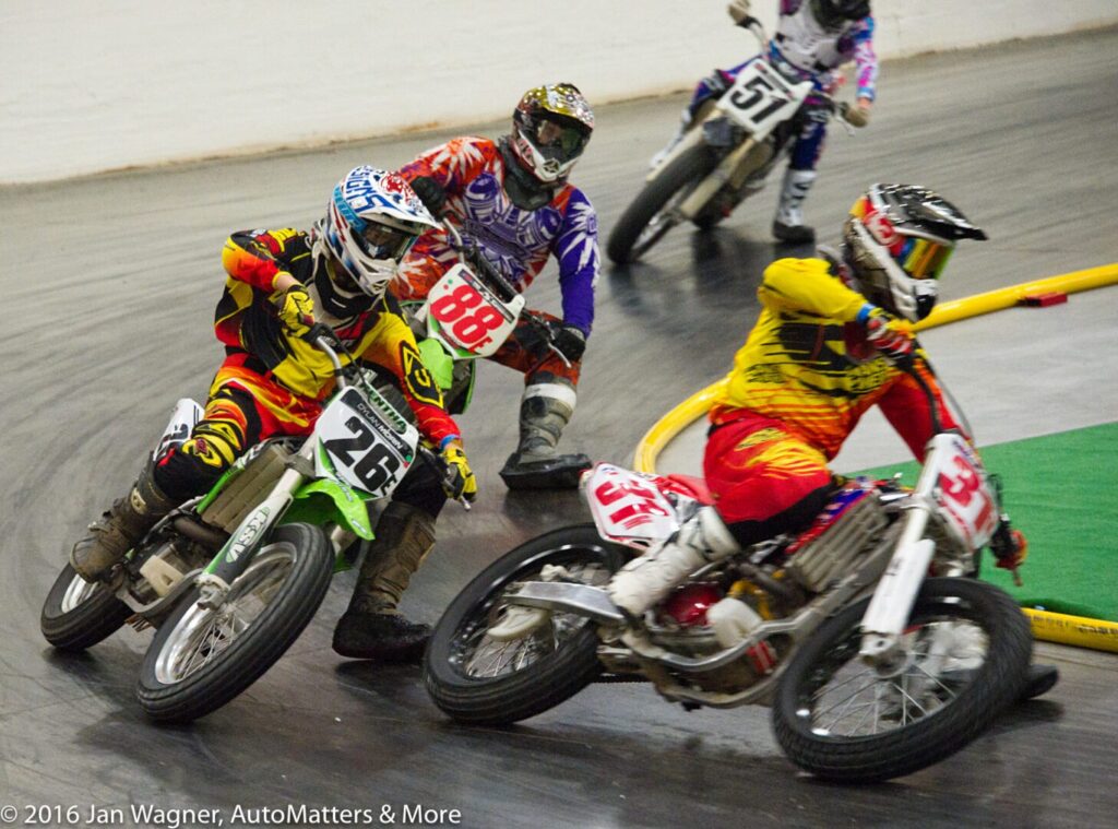 A group of people riding motorcycles on a track.