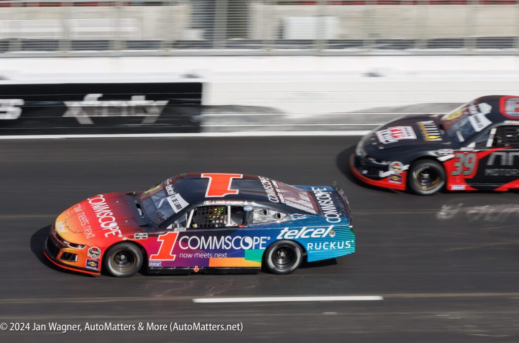 Two nascar cars racing on a track.