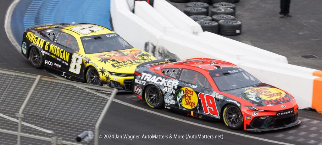 Two nascar cars racing on a track.