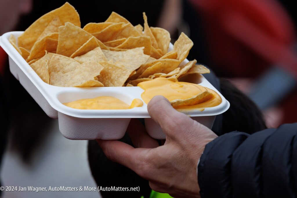 A person holding a tray of nachos.