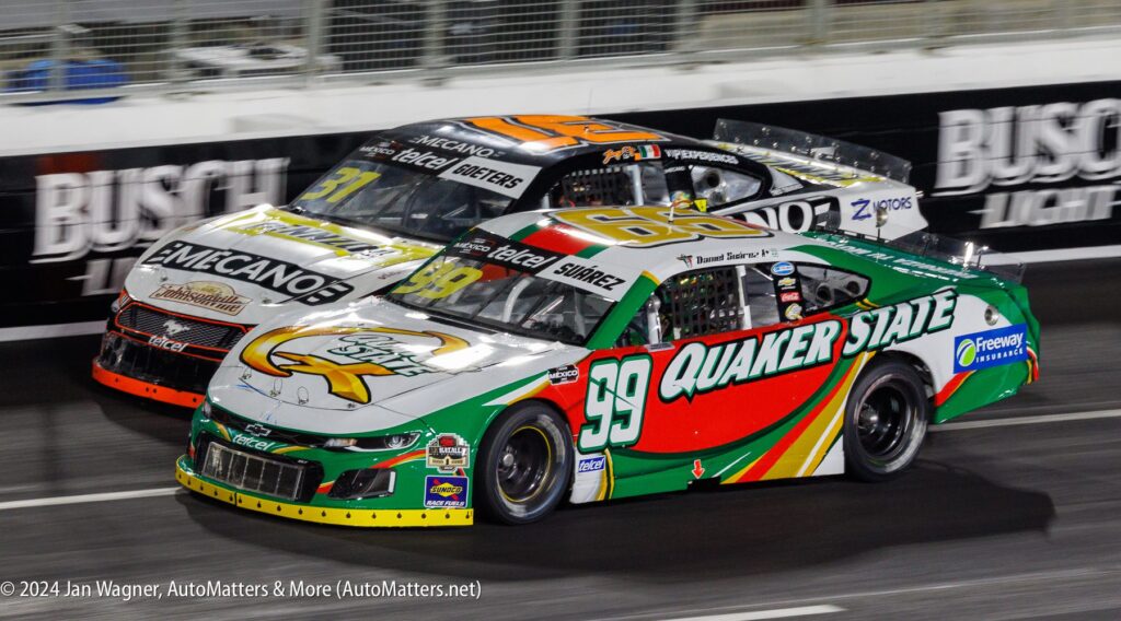 Two chevrolet nascar cars racing on a track.