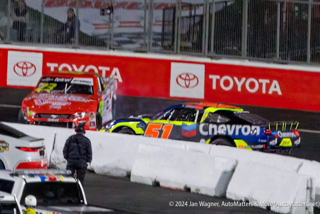 Two nascar cars on the track at a race.