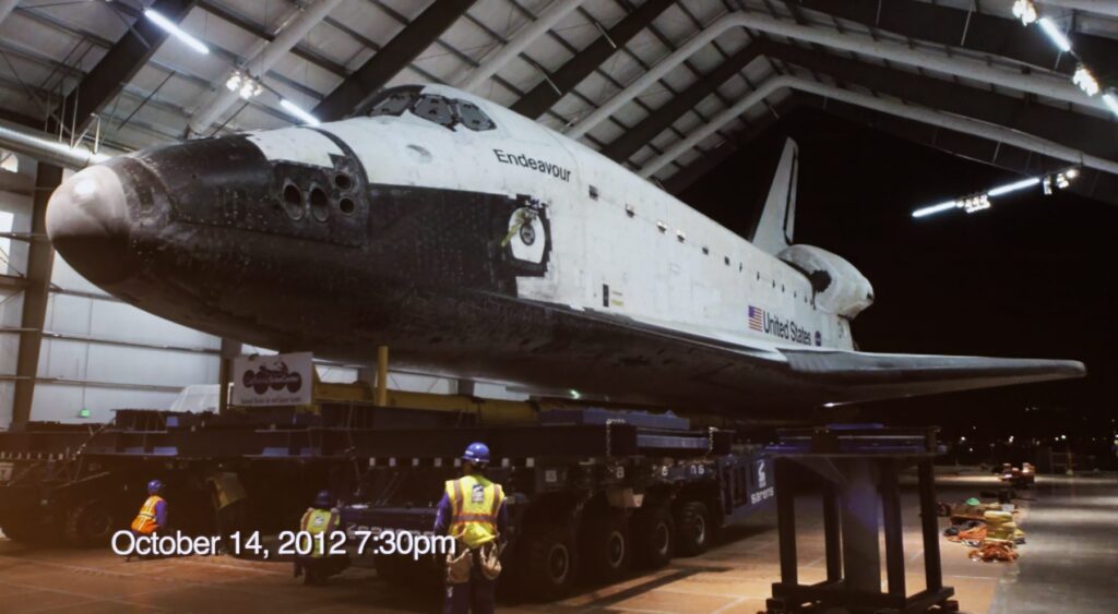 Nasa's space shuttle is being loaded into a hangar.