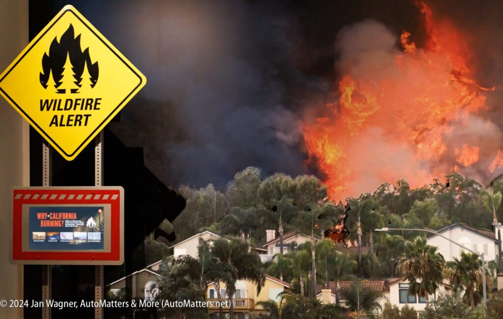 A sign warning of a wildfire in front of a house.