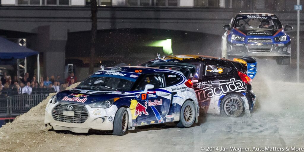 A group of rally cars on a dirt track at night.