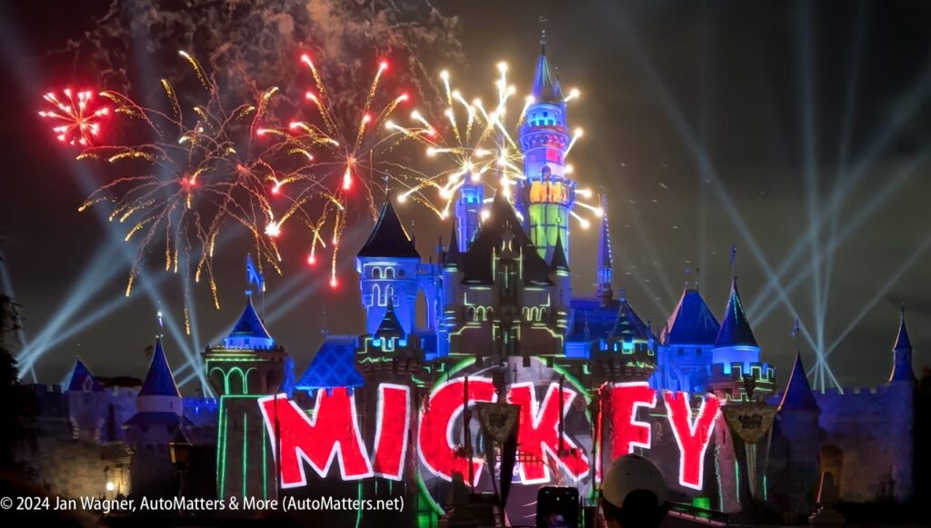 Mickey's disneyland castle lit up with fireworks.
