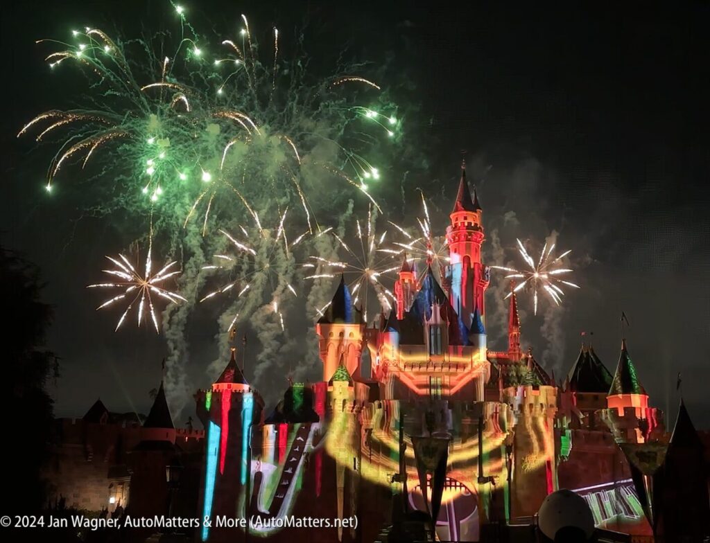 Disneyland's cinderella castle lit up with fireworks.