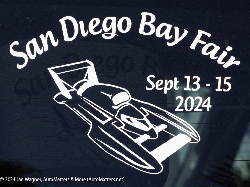 White graphic decal on glass showing a hydroplane boat and text: "San Diego Bay Fair Sept 13-15 2024." Photo credit noted at the bottom.