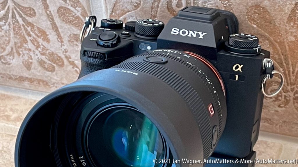 Sony Alpha 1 camera with attached lens, placed on a textured surface.