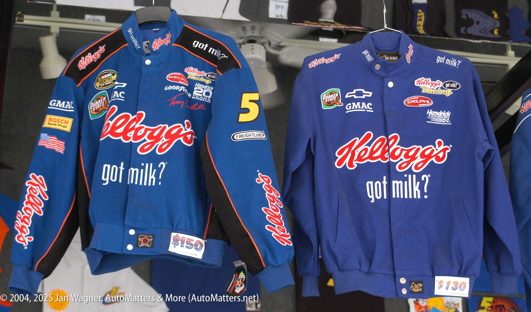 Two blue racing jackets with Kellogg’s and “got milk?” logos are displayed for sale, priced at $150 and $130. Other sponsor logos are also visible on the jackets.