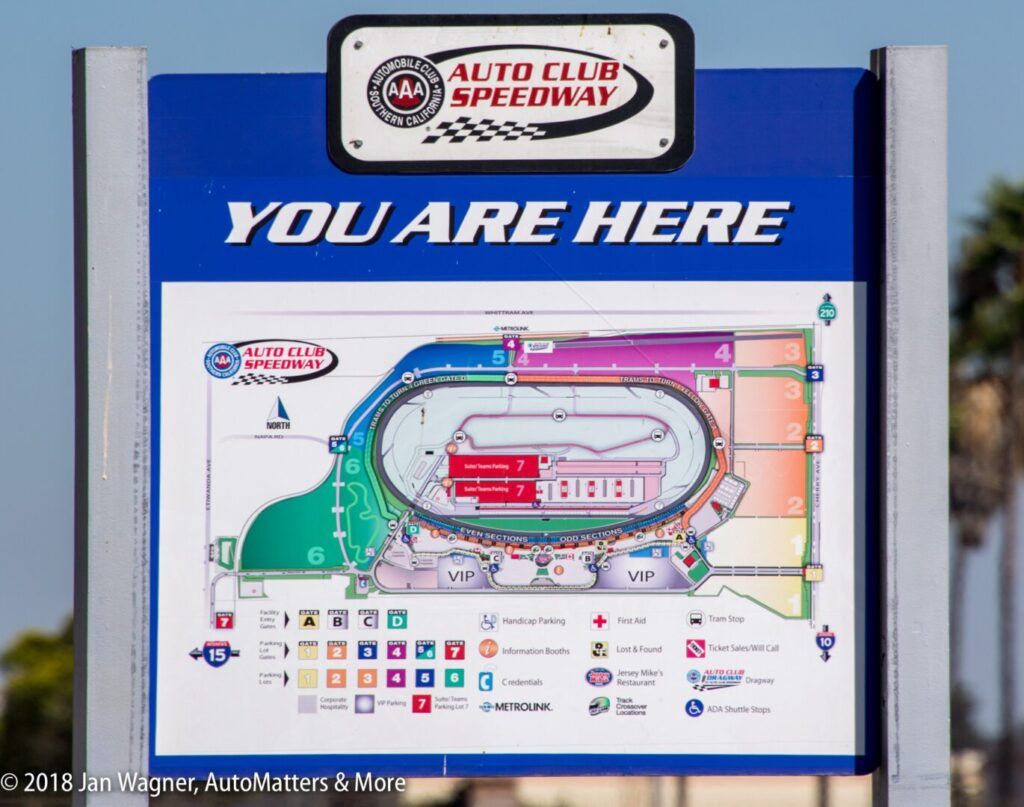 A sign at Auto Club Speedway shows a "You Are Here" map with labeled sections, parking, and amenities.