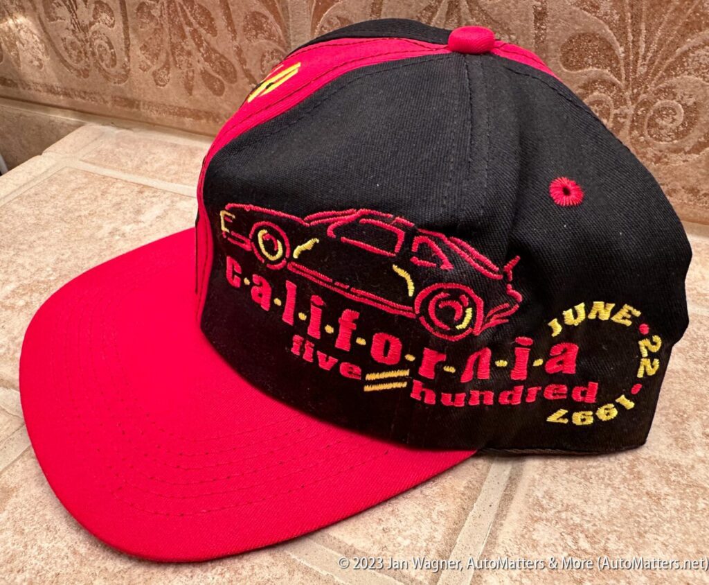 Red and black cap featuring an embroidered car, "California five hundred," and the date "June 22, 1997" on the side.