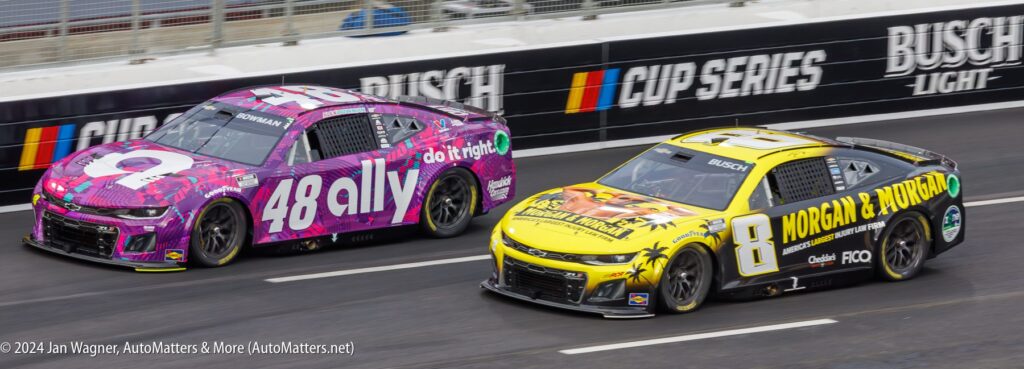 Two NASCAR race cars, number 48 (purple Ally) and number 8 (yellow Morgan & Morgan), drive side by side on a track during a race.