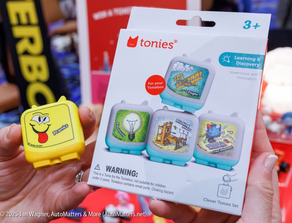 A hand holds a yellow Tonies audio figurine beside a Tonies Clever Tonies Set box featuring four themed figurines for children ages 3 and up.