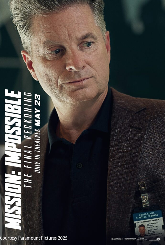 A man with gray hair wearing a dark blazer and ID badge looks to the side. Text reads: "Mission: Impossible The Final Reckoning Only in Theaters May 23.
