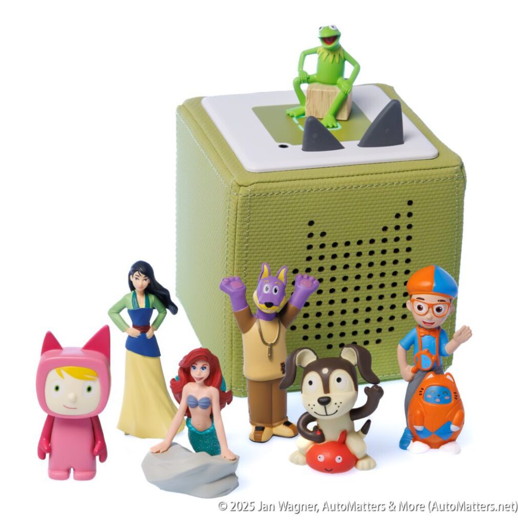 A green Toniebox audio player is surrounded by seven character figurines, including animals and people, positioned on a white background.