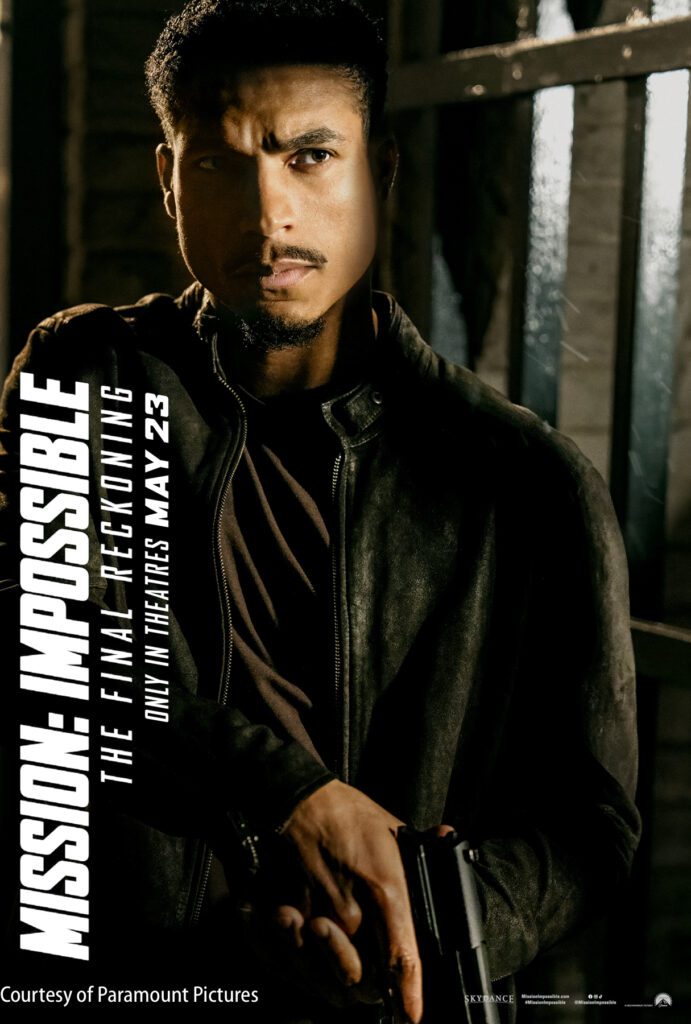 A man in a leather jacket stands in front of metal bars, holding a handgun. Text promotes "Mission: Impossible – The Final Reckoning," in theaters May 23. Courtesy of Paramount Pictures.