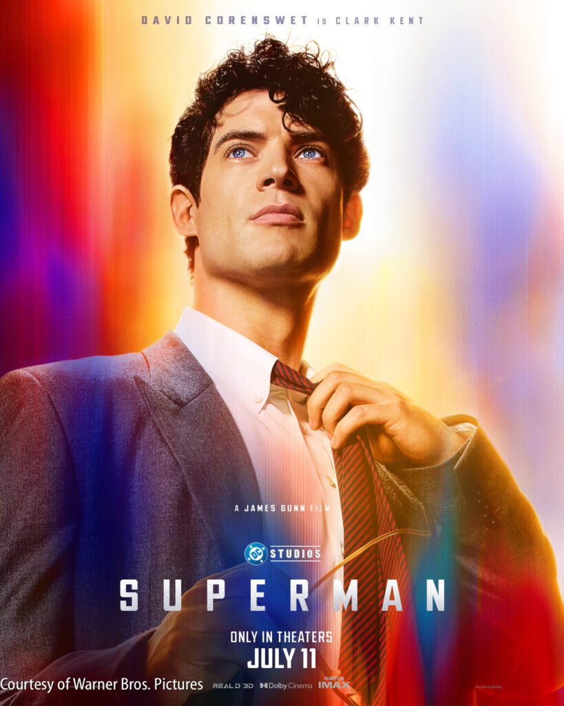 A man in a suit adjusts his tie with a serious expression; colorful light flares surround him. The text promotes the film "Superman," releasing July 11.