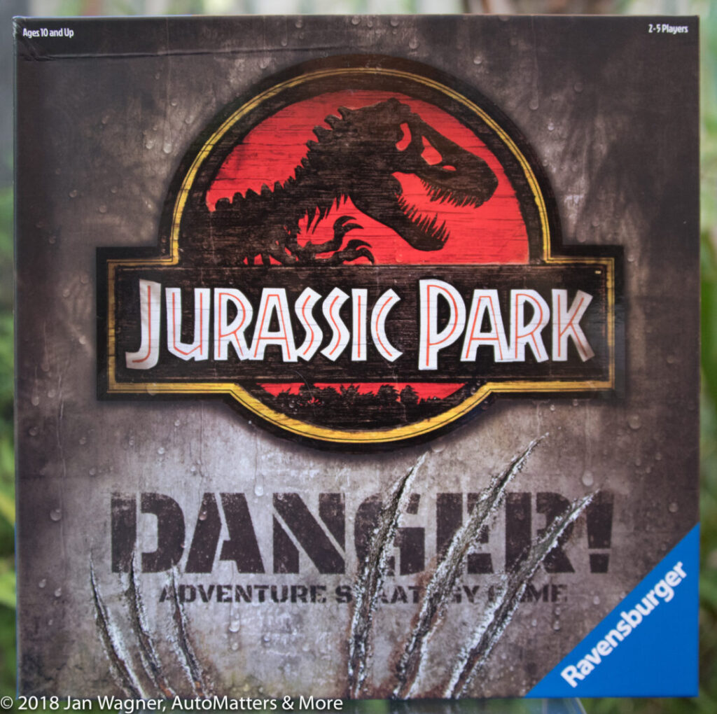 Close-up of the Jurassic Park: Danger! Adventure Strategy Game box showing the iconic red dinosaur logo and Ravensburger branding.