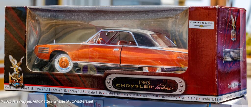 A 1:18 scale model of a 1963 Chrysler Turbine car displayed in its original packaging with branding and details visible.