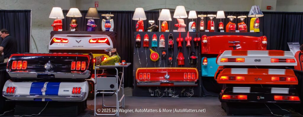 A display of lamps and furniture made from classic car parts, including taillights, trunks, and rear sections of various vintage cars, at an automotive show.