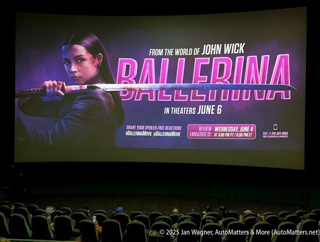 A movie theater screen displays a promotional image for the film "Ballerina," featuring a woman holding a sword, with release date details and social media hashtags.