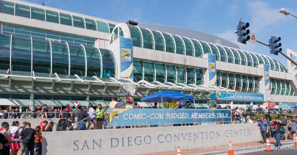 Crowd gathers outside San Diego Convention Center under a banner reading "Comic-Con Badged Members Only" during Comic-Con event.