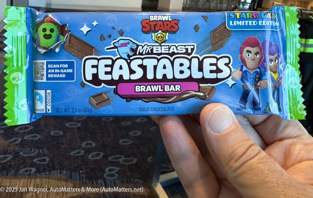 A hand holds a limited edition MrBeast Feastables Brawl Bar milk chocolate featuring Brawl Stars branding and in-game reward QR code on the wrapper.