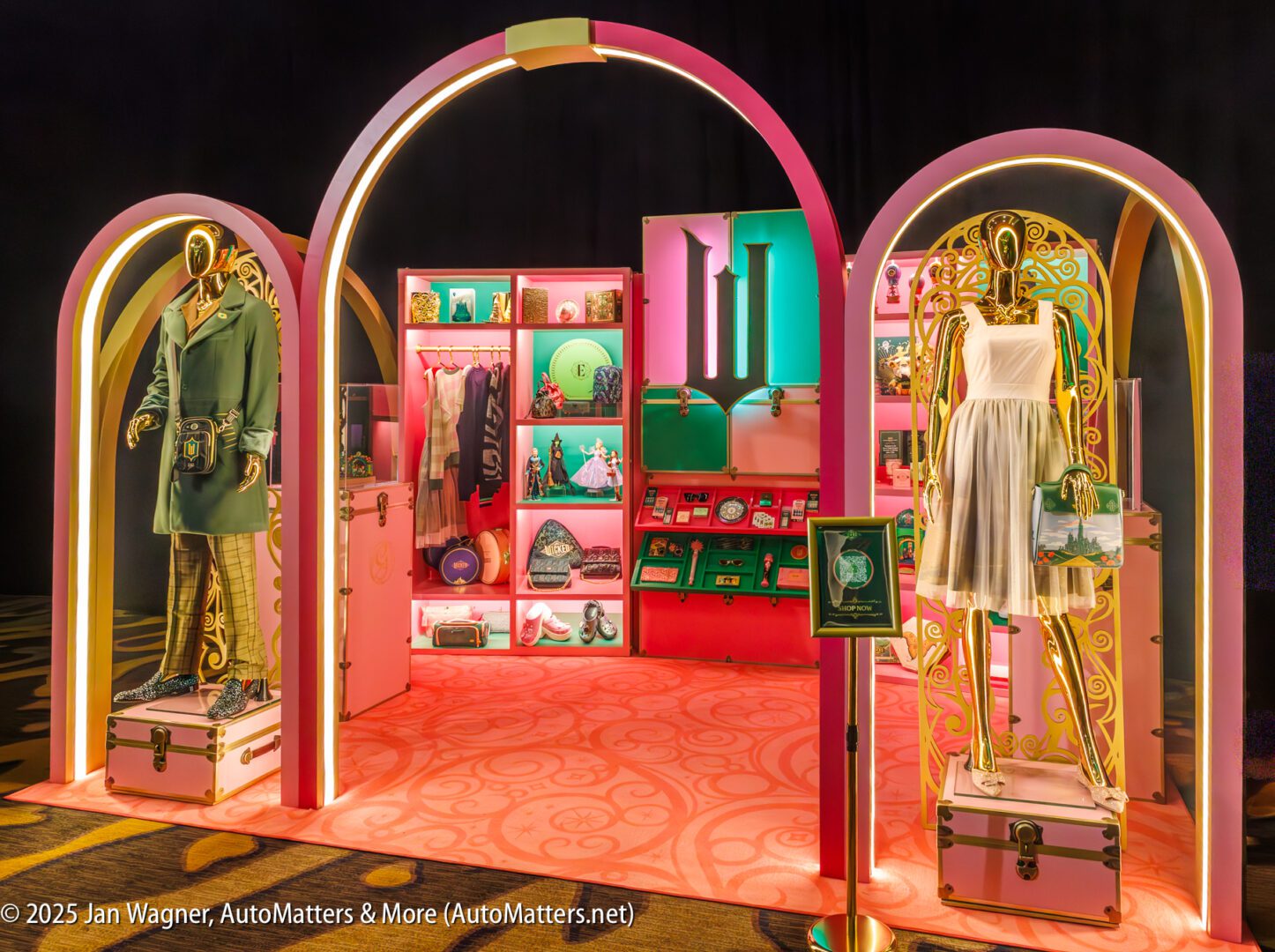 A brightly lit display features two mannequins dressed in fashionable outfits, with shelves of colorful accessories and decor items arranged between them.