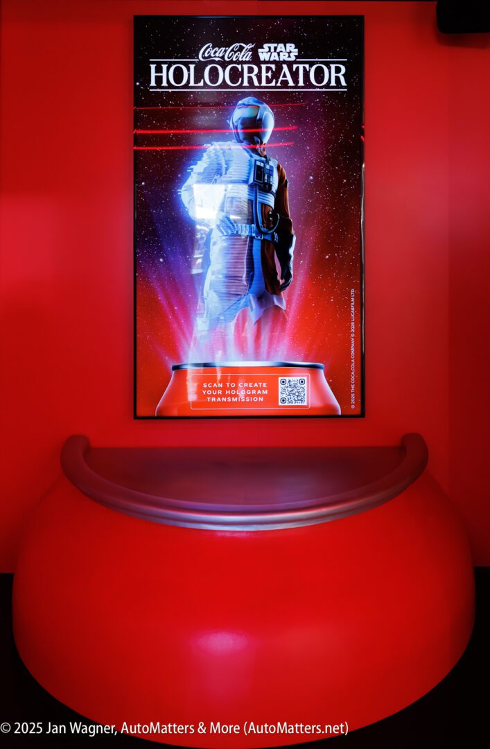 A digital poster for "Coca-Cola Star Wars Holocreator" is displayed above a red, rounded seating area against a red wall.