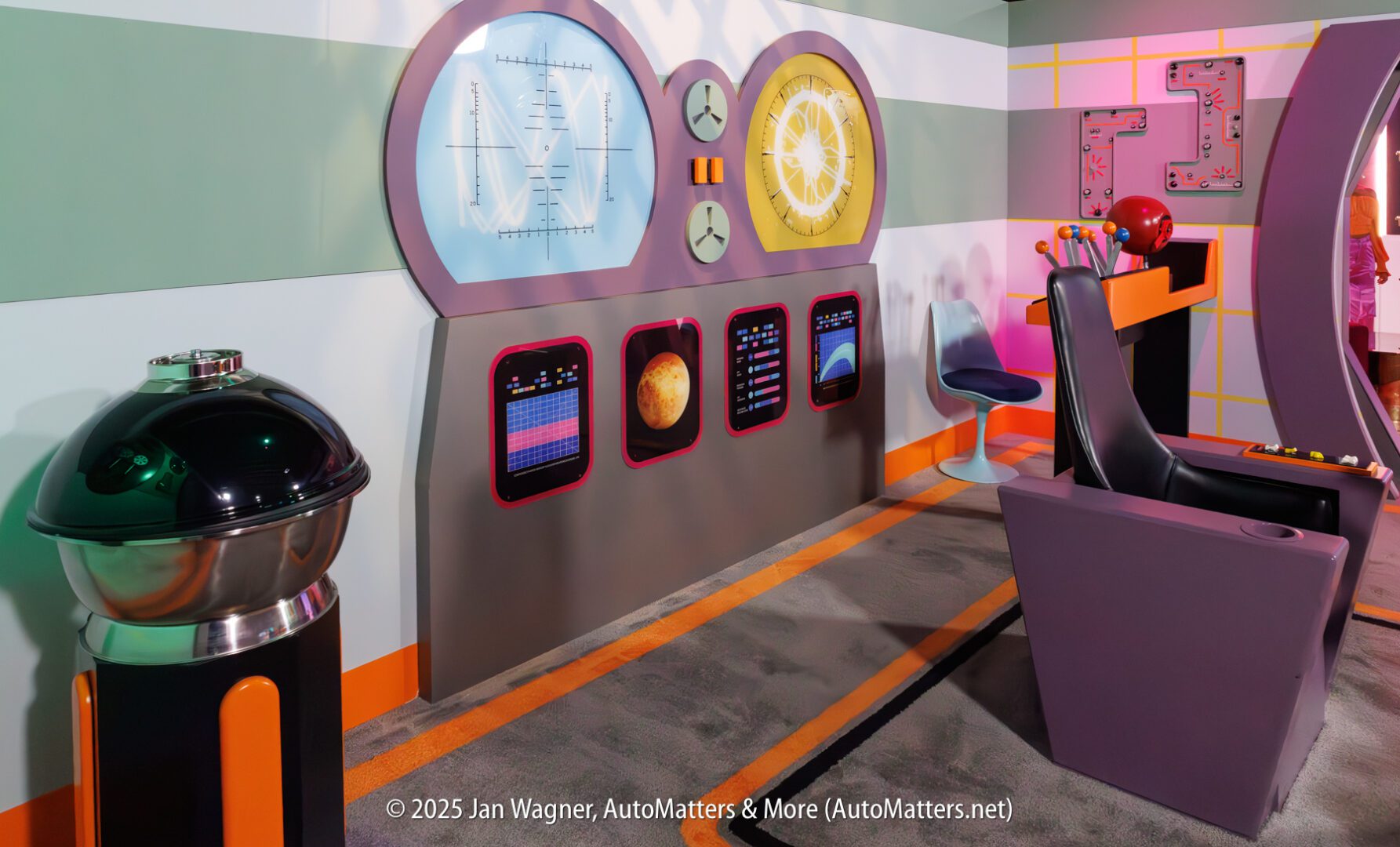 A retro-futuristic control room with colorful dials, screens displaying graphs and planets, a round metallic device, and modernistic chairs.