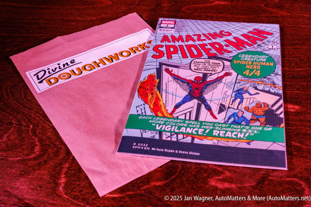 A Marvel Amazing Spider-Man comic book and a Divine Doughworks bakery bag are placed on a wooden surface.