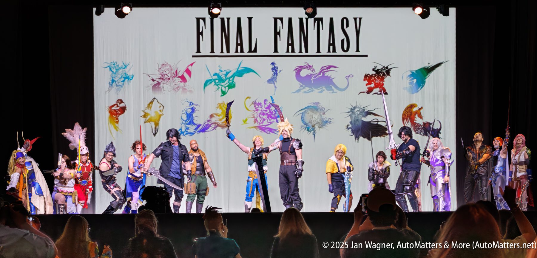 A group of cosplayers dressed as Final Fantasy characters pose on stage in front of a large screen displaying the “Final Fantasy” logo and character silhouettes.