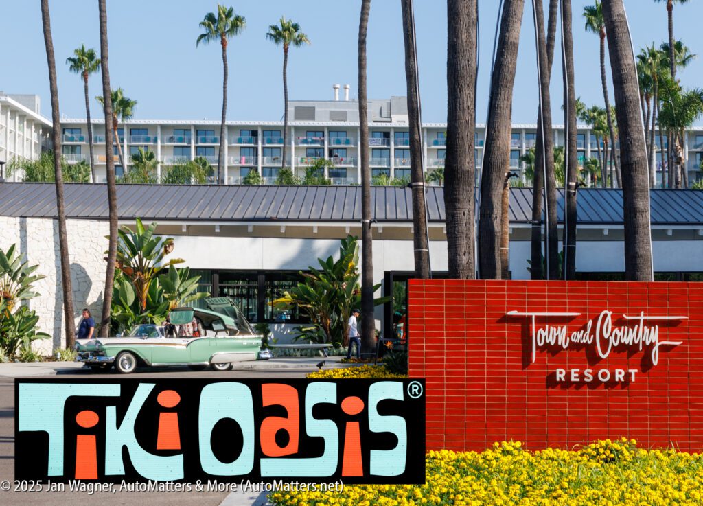 A vintage green car is parked in front of the Town and Country Resort, with a "Tiki Oasis" sign and palm trees visible in the foreground.