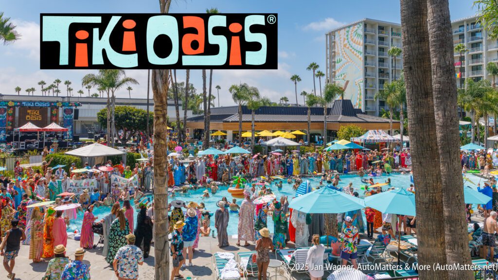 A large crowd in tropical attire gathers around a hotel pool for the Tiki Oasis event, with palm trees and tall buildings in the background.