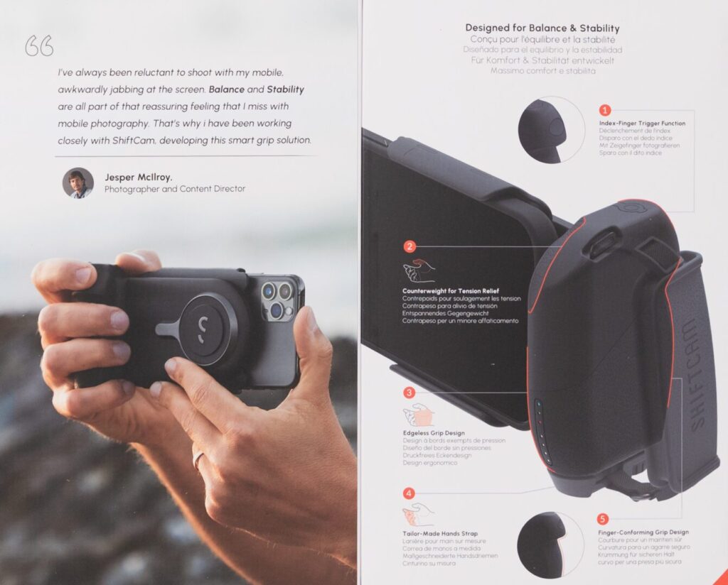 A person holds a smartphone mounted in a black grip accessory. The adjacent page displays the grip's features with labeled diagrams and English-Spanish descriptions.