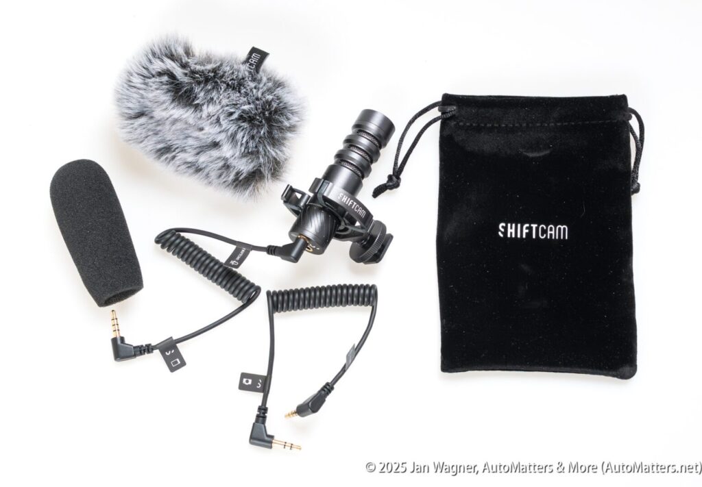 A compact microphone with a furry windscreen, a foam cover, two coiled audio cables, a mounting clip, and a black SHIFTCAM drawstring pouch on a white background.