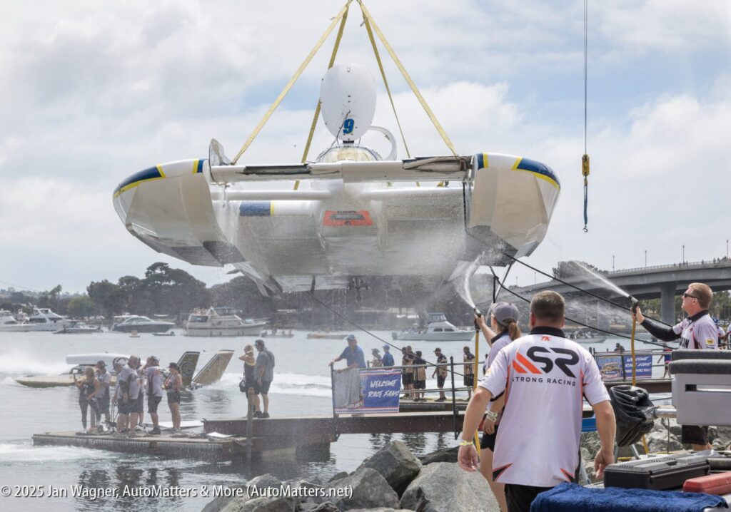 A large white and blue flying boat being sprayed with water.