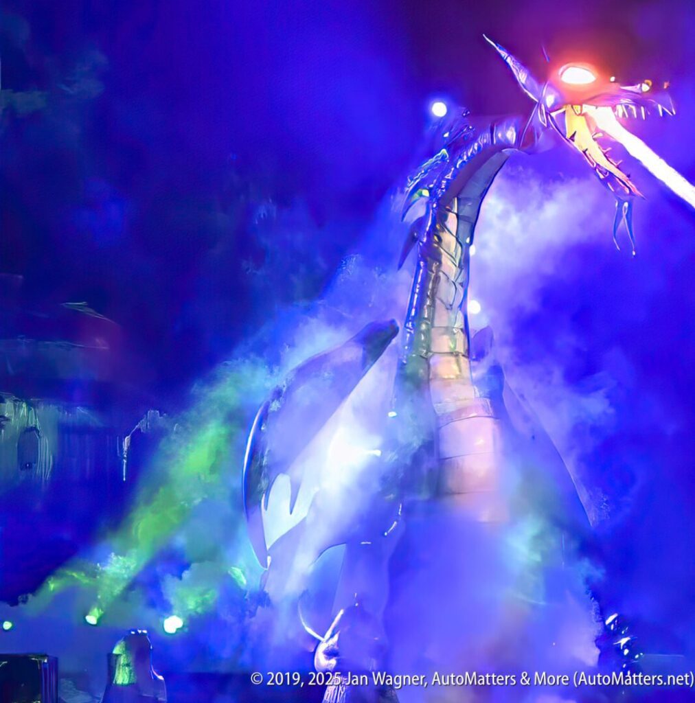 A large mechanical dragon breathes fire during a nighttime show, surrounded by colorful lights and smoke effects.