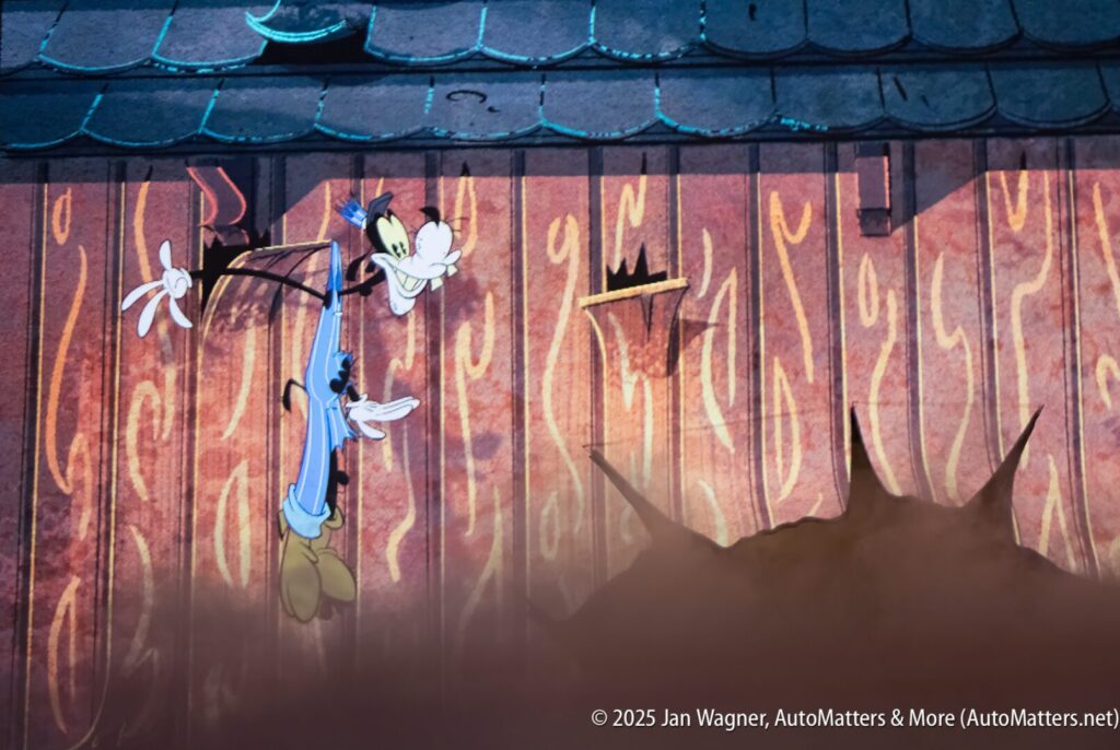 Animated image of Goofy hanging from a nail on a wooden wall with a large hole below and visible cracks, as seen in a Disney cartoon scene.