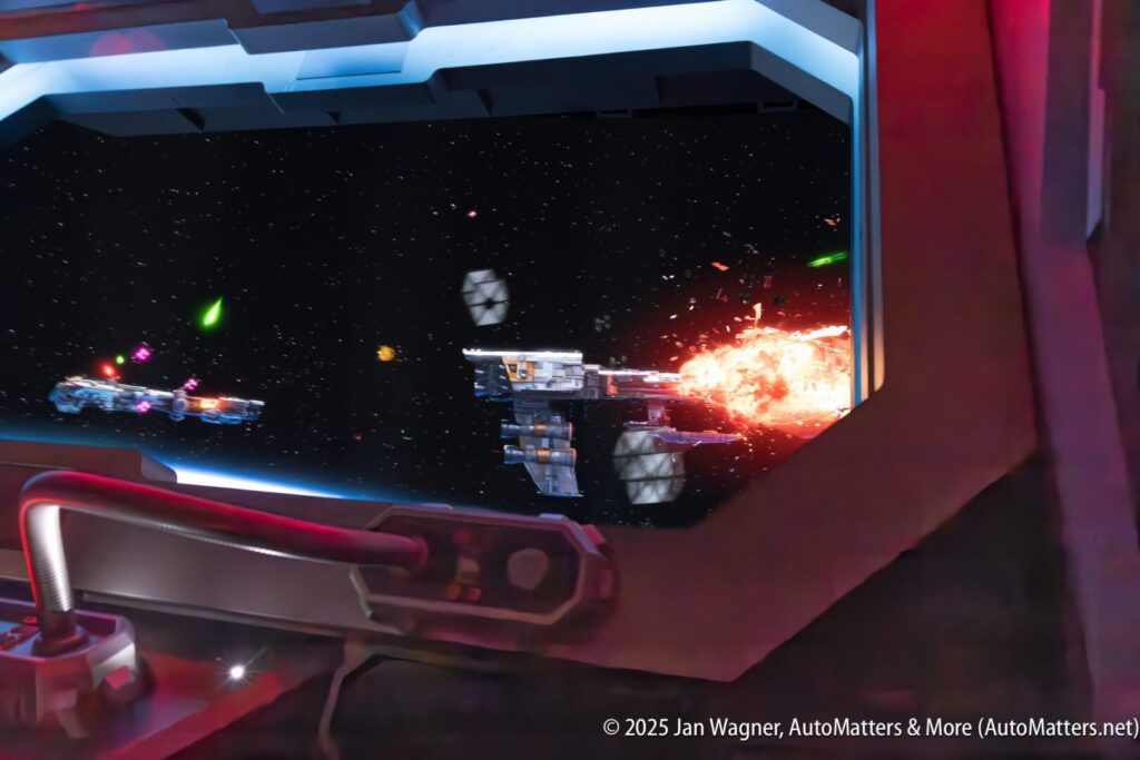 View from inside a spaceship cockpit showing a space battle, with one spaceship exploding and others firing energy weapons in a star-filled background.