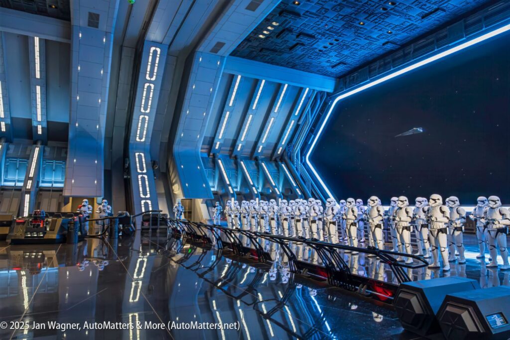 A group of Star Wars Stormtrooper figures stand in formation inside a futuristic, blue-lit spaceship interior display.