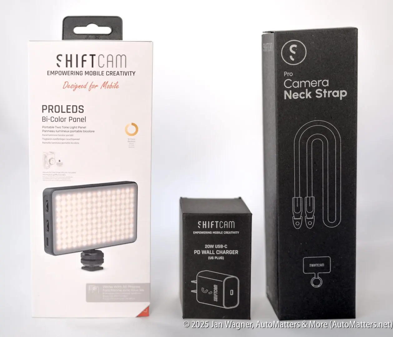Three photography accessories in boxes: a SHIFTCAM PROLEDS Bi-Color Panel, a 20W USB-C wall charger, and a Pro Camera Neck Strap, displayed side by side.