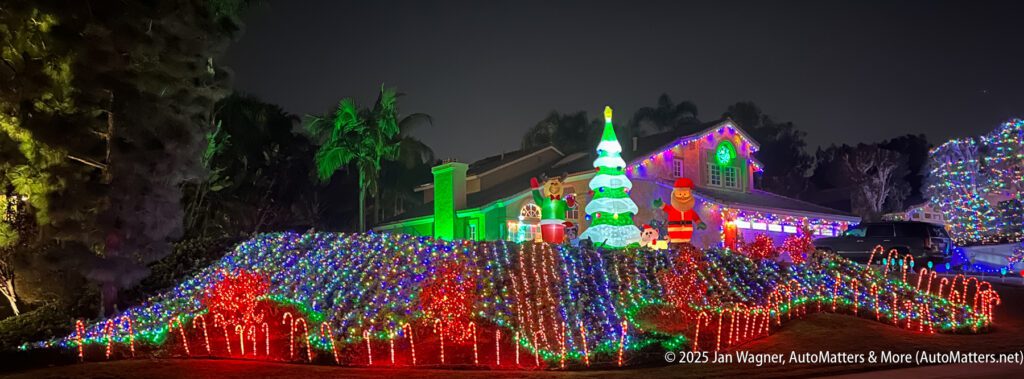 A house and yard decorated with colorful Christmas lights, inflatable holiday figures, a Christmas tree, and illuminated candy canes at night.