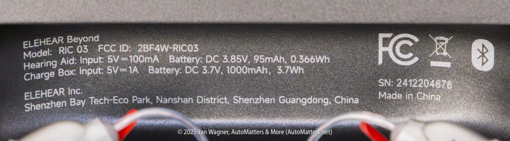 Close-up of a product label displaying model, FCC ID, power input and battery specifications, manufacturer details, and regulatory symbols for an ELEHEAR device.