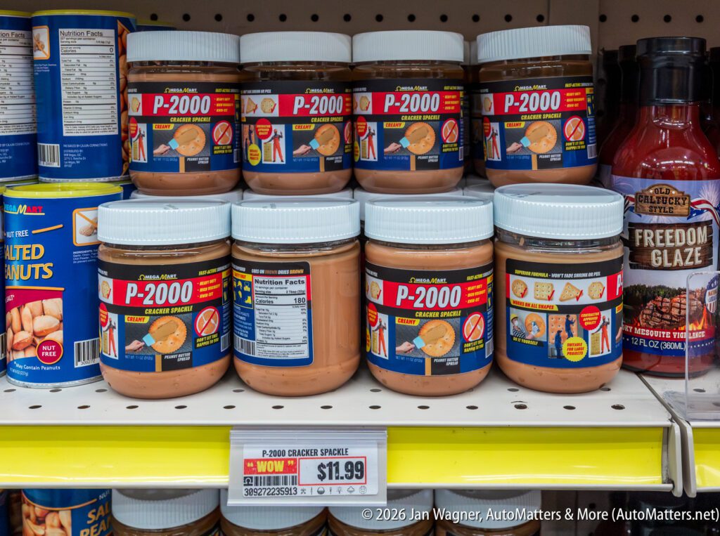 Jars of P-2000 cracker spread are displayed on a grocery store shelf with a price tag showing $11.99.