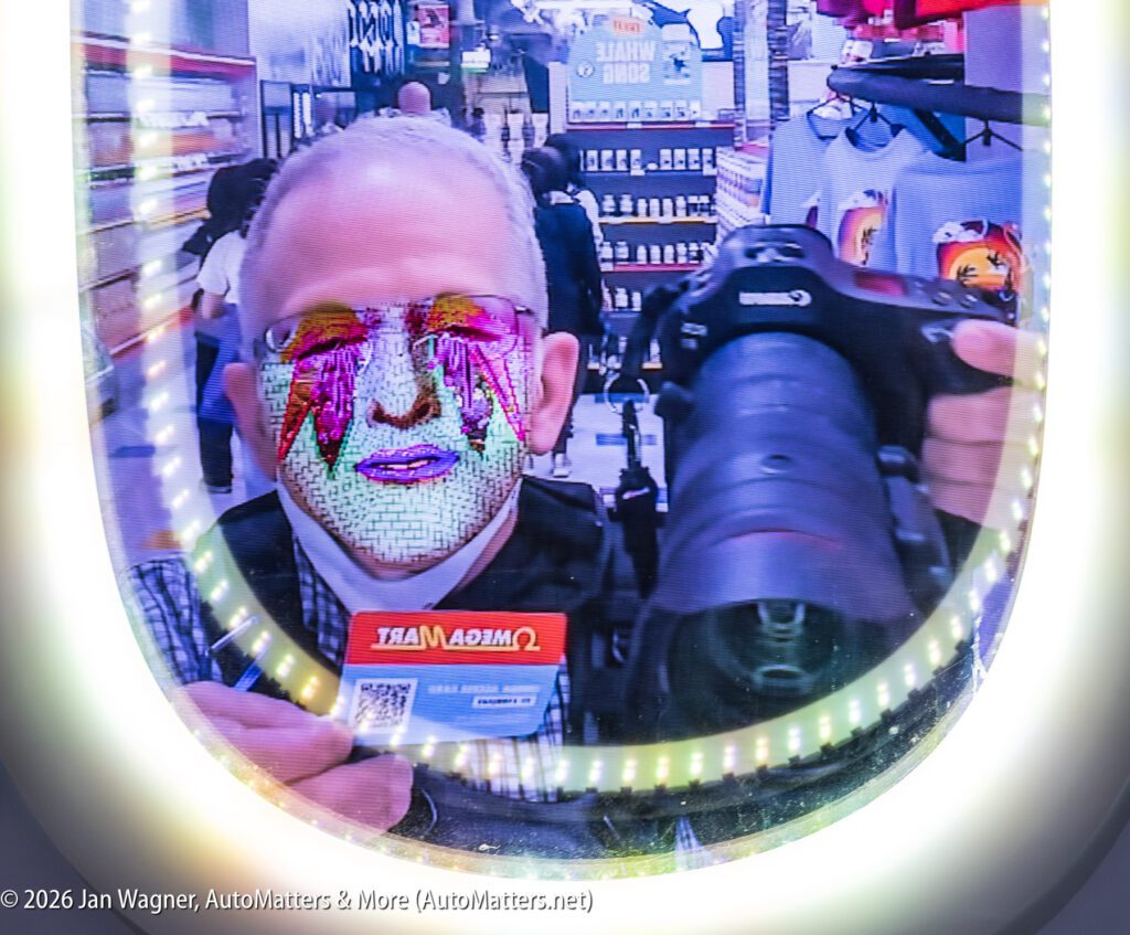 A person takes a selfie in a store mirror while holding a camera and a membership card; their face is overlaid with a colorful digital filter.