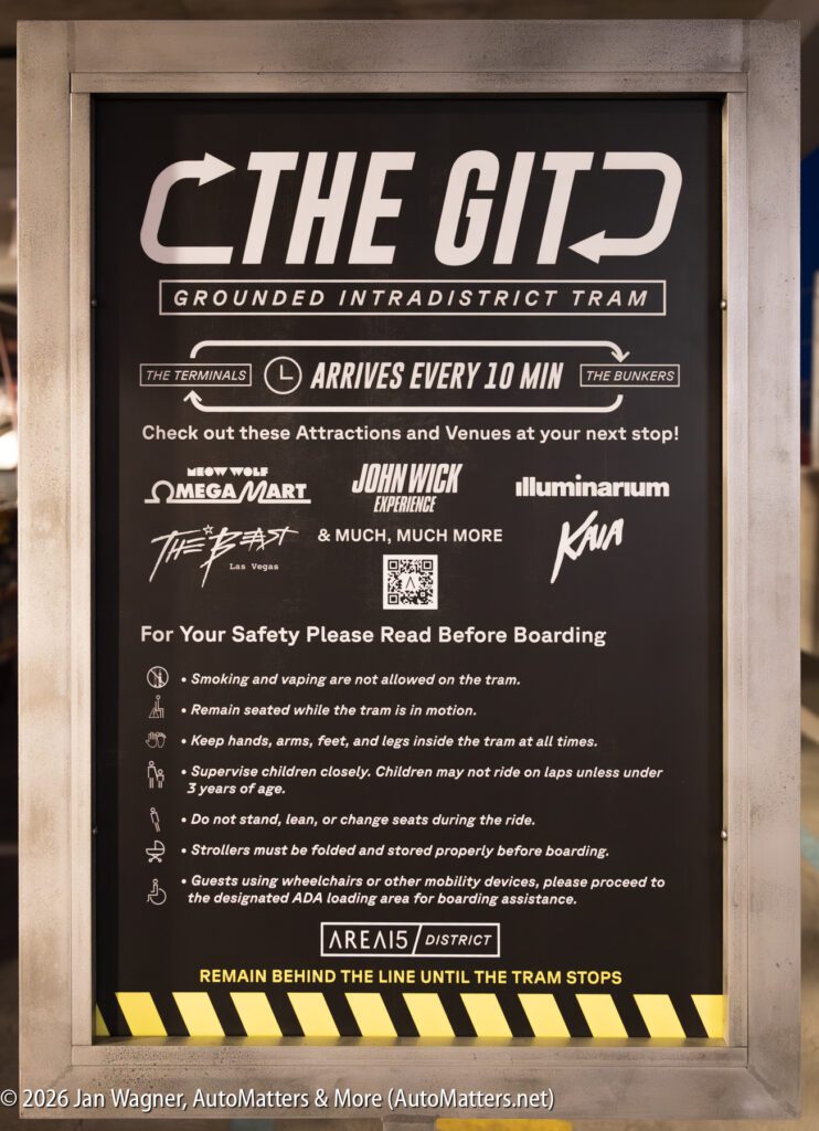 Sign for "The GITD" tram lists nearby attractions, safety rules for boarding, and notes that the tram arrives every 10 minutes. Text is displayed within a metal frame.